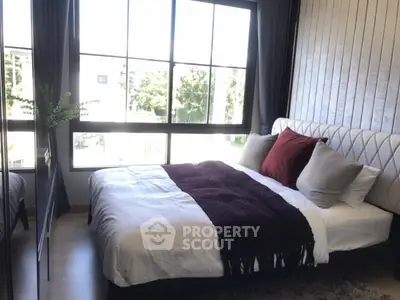 Cozy bedroom with large window and stylish decor in modern apartment
