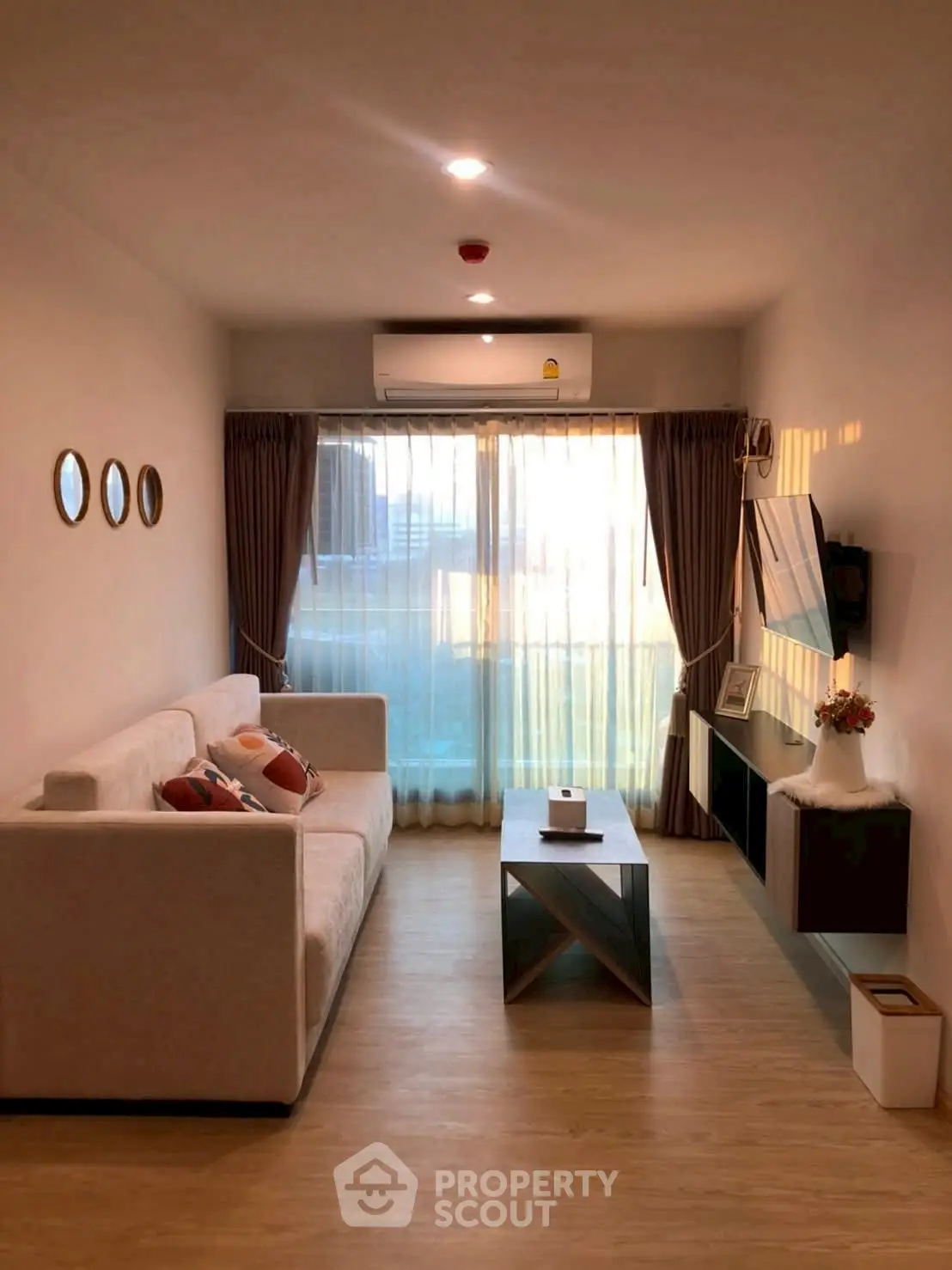 Modern living room with cozy sofa, stylish decor, and large window for natural light.