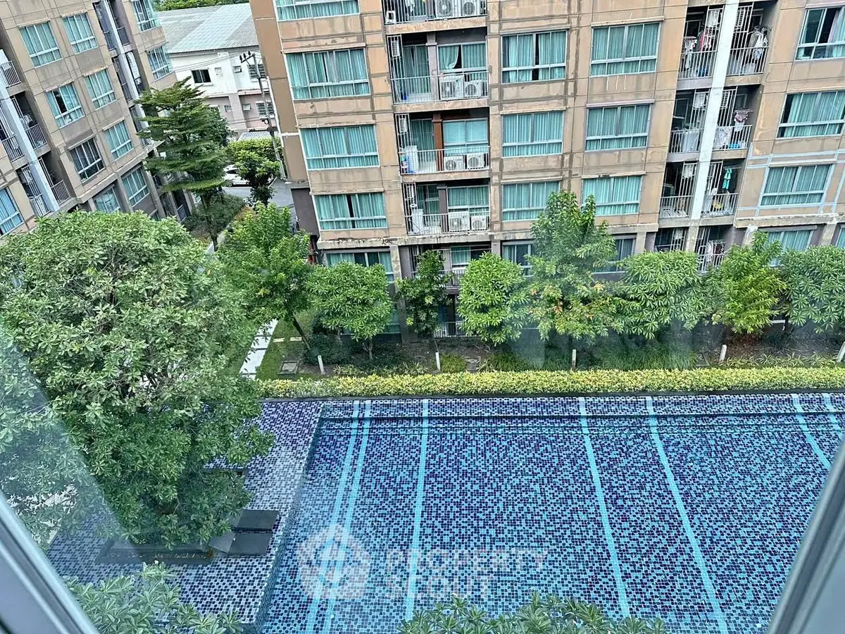 Stunning view of modern apartment complex with pool and lush greenery