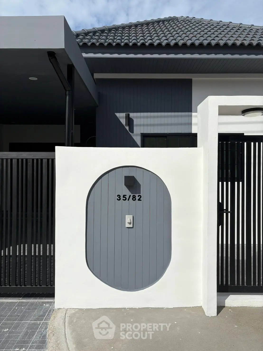 Modern residential entrance with sleek design and unique address display, showcasing contemporary architecture.