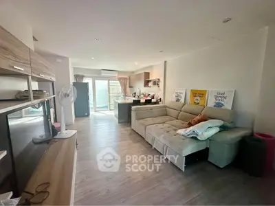 Spacious modern living room with open kitchen and cozy sofa, perfect for family gatherings.