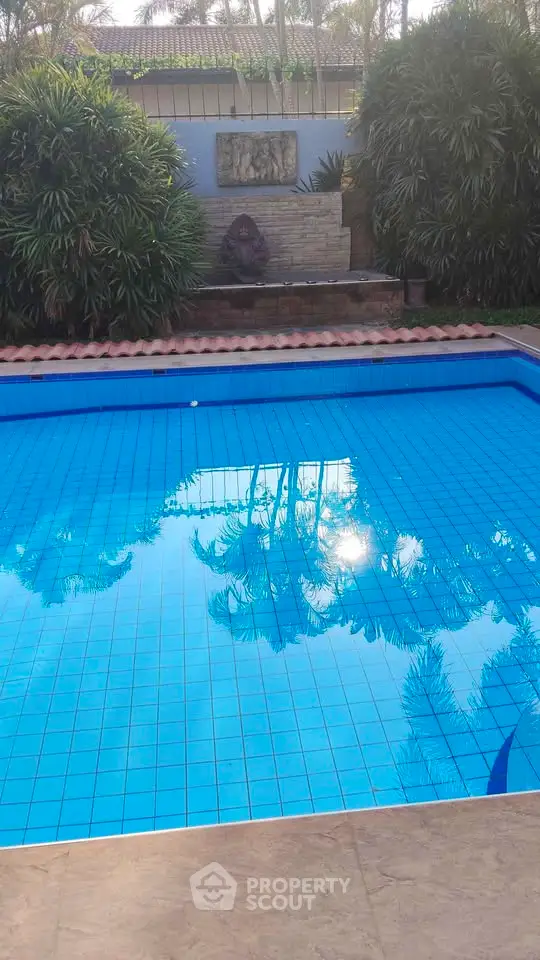 Stunning outdoor pool area with lush greenery and serene ambiance, perfect for relaxation and leisure.