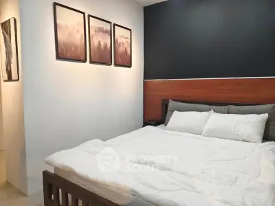 Cozy bedroom with modern decor and stylish wall art, perfect for relaxation.