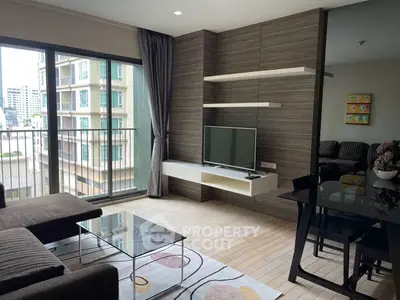 Modern living room with sleek furniture and city view from balcony, perfect for urban living.