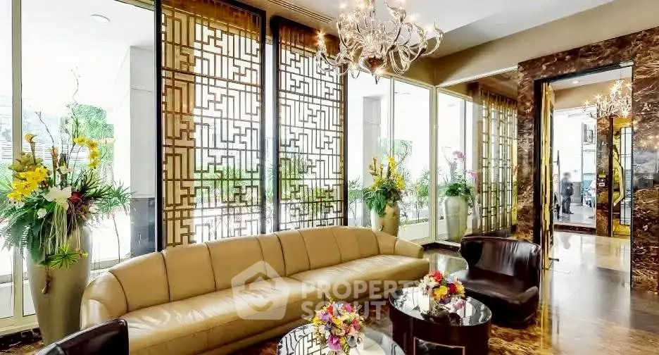 Luxurious living room with elegant decor and large windows, featuring a plush sofa and stylish chandelier.