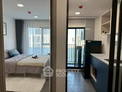 Modern studio apartment with cozy bedroom and sleek kitchen, featuring a balcony with natural light.