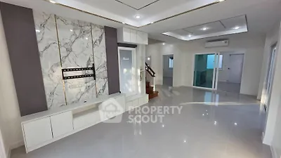 Spacious modern living room with marble accent wall and sleek white cabinetry
