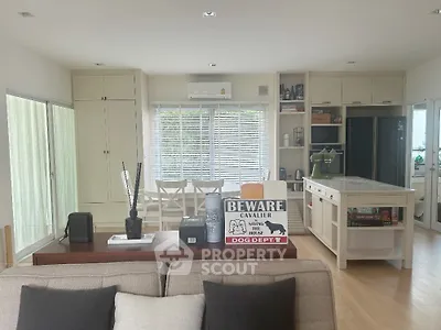 Spacious and bright living room with modern furnishings, elegant white cabinetry, and a cozy seating area perfect for relaxation and entertainment.