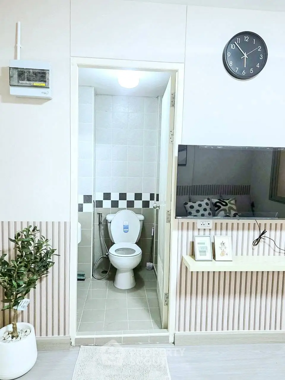 Modern bathroom with stylish decor and wall-mounted TV in cozy apartment.