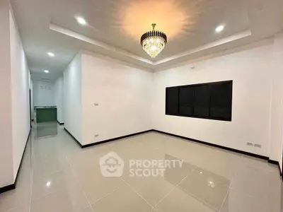 Spacious modern living room with elegant chandelier and glossy tiled flooring