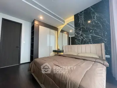 Luxurious bedroom with elegant marble accent wall and modern lighting