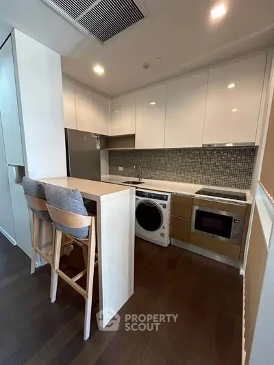 Modern kitchen with sleek cabinetry, integrated appliances, and stylish breakfast bar seating.