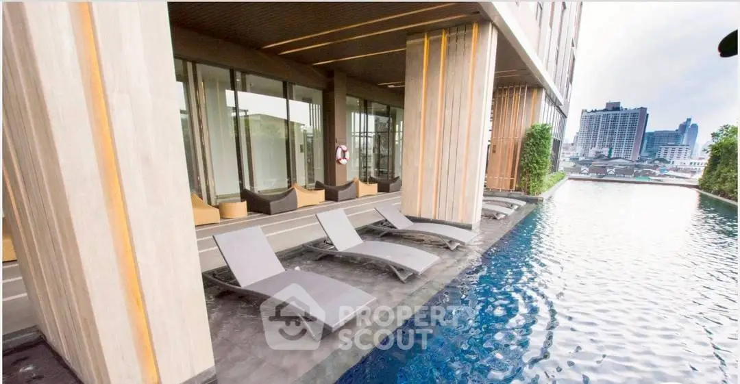 Luxurious rooftop pool with modern lounge chairs and city skyline view, perfect for relaxation and leisure.