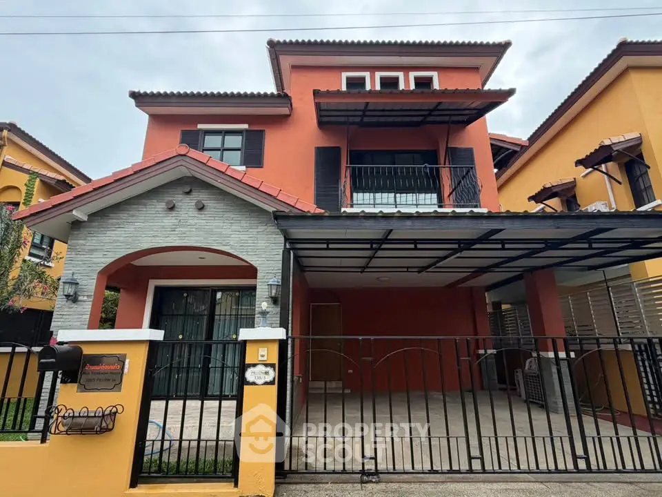 Charming two-story house with a spacious carport and vibrant exterior colors, perfect for family living.