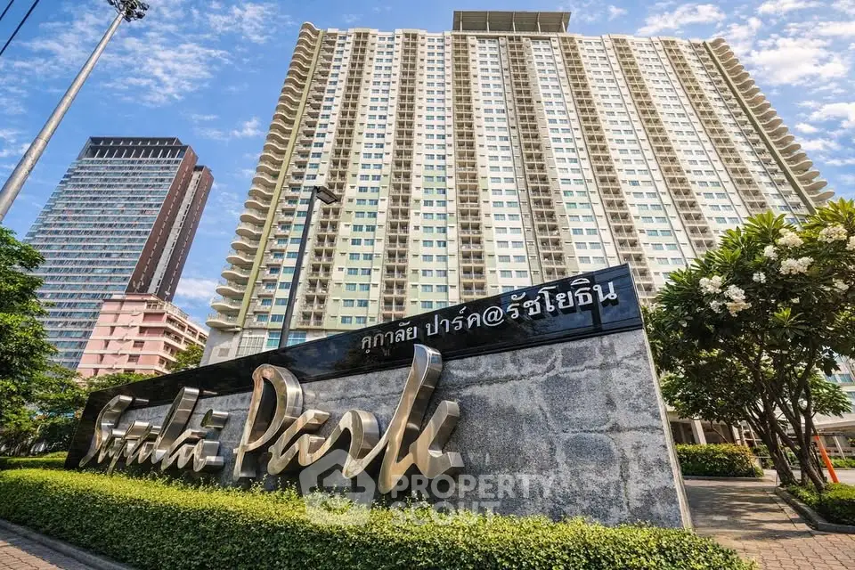 Stunning high-rise building with modern architecture and lush landscaping in prime urban location.