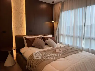 Luxurious bedroom with modern decor and large window for natural light.