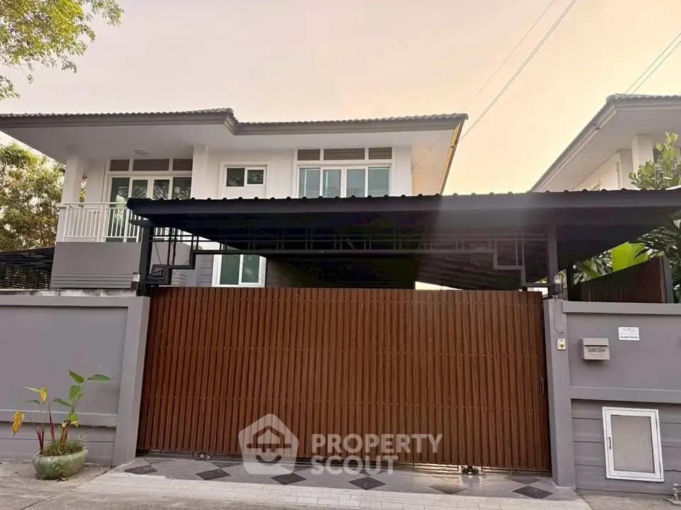 Modern two-story house with gated entrance and spacious driveway