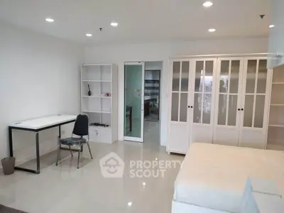 Spacious modern bedroom with sleek white furniture and ample storage space