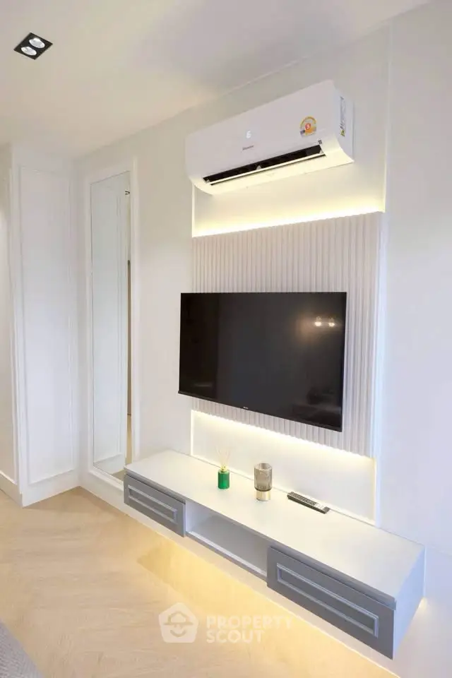 Modern living room with sleek TV setup and air conditioning unit