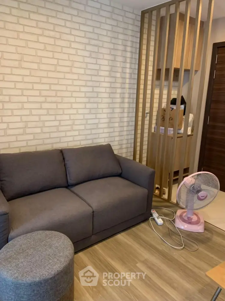 Modern living room with stylish brick wall and cozy gray sofa