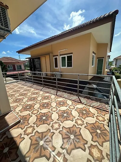 Spacious balcony with decorative tiles and modern exterior view under clear blue sky.