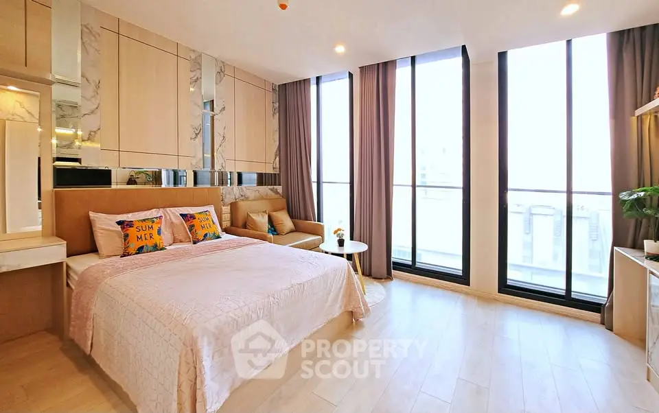 Luxurious bedroom with floor-to-ceiling windows and elegant decor in modern apartment.