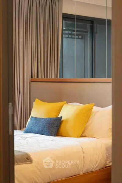 Cozy bedroom with modern decor and vibrant pillows, perfect for relaxation.