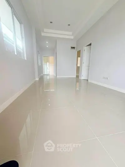 Spacious modern hallway with glossy tiled flooring and recessed lighting