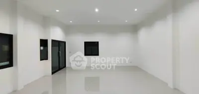 Spacious empty room with glossy tiled floor and recessed lighting