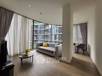 Spacious modern living room with floor-to-ceiling windows and stylish furniture in a luxury apartment.