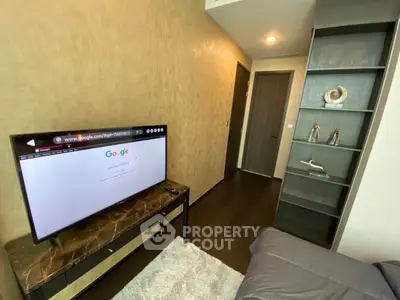 Modern living room with sleek TV setup and stylish shelving in a contemporary apartment.
