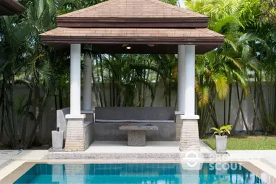 Luxurious outdoor poolside cabana with tropical landscaping