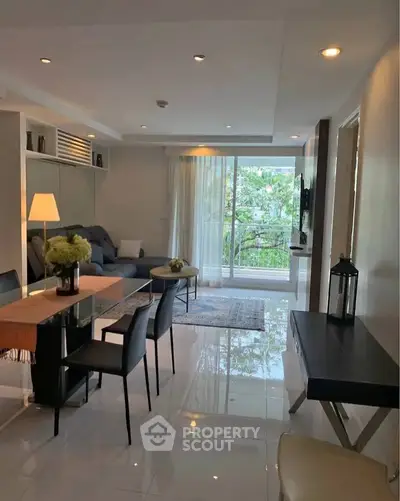 Modern living room with sleek furniture and large windows offering lush garden views.