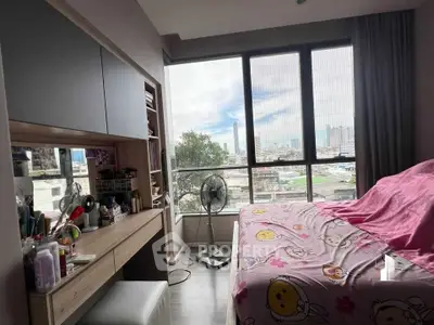 Cozy bedroom with city view, featuring a large window, desk, and bed with colorful bedding.