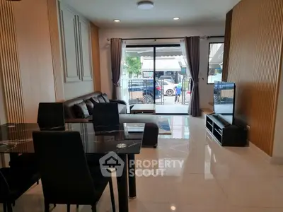 Modern living room with elegant dining area and large windows for natural light.