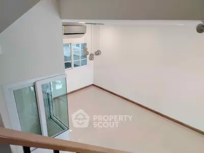 Spacious modern living room with high ceiling and elegant lighting fixtures.