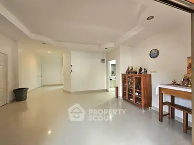 Spacious living room with elegant decor and ample natural light, perfect for family gatherings.