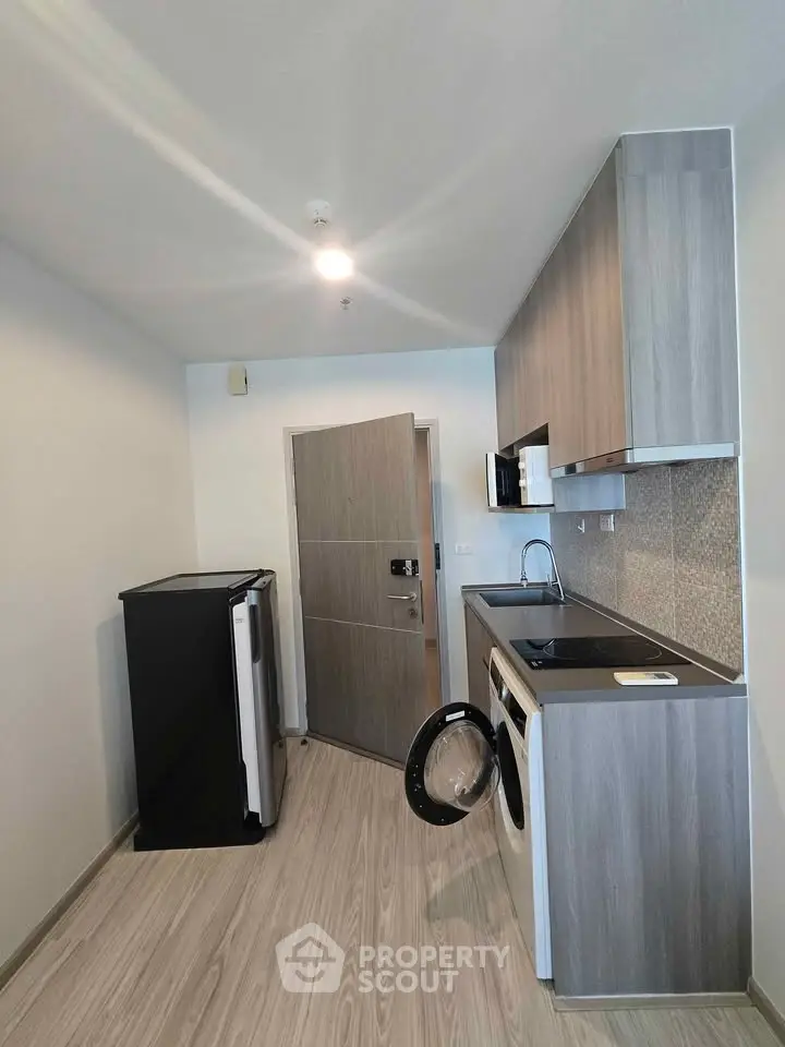 Modern kitchen with sleek cabinetry and built-in appliances in a compact layout.