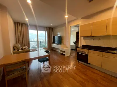 Spacious open-plan living room with modern kitchen and city view balcony.