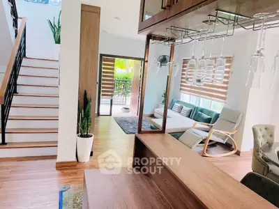Modern open-plan living room with stylish decor and wooden staircase