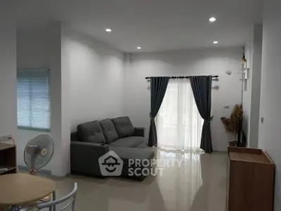 Modern living room with gray sofa and elegant curtains in a cozy apartment.