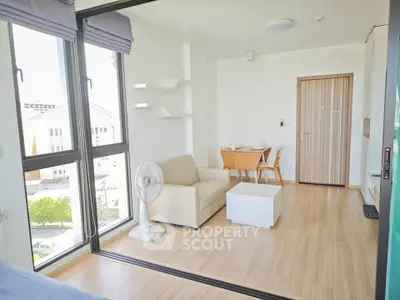Bright modern living room with large windows and minimalist furniture in a stylish apartment.