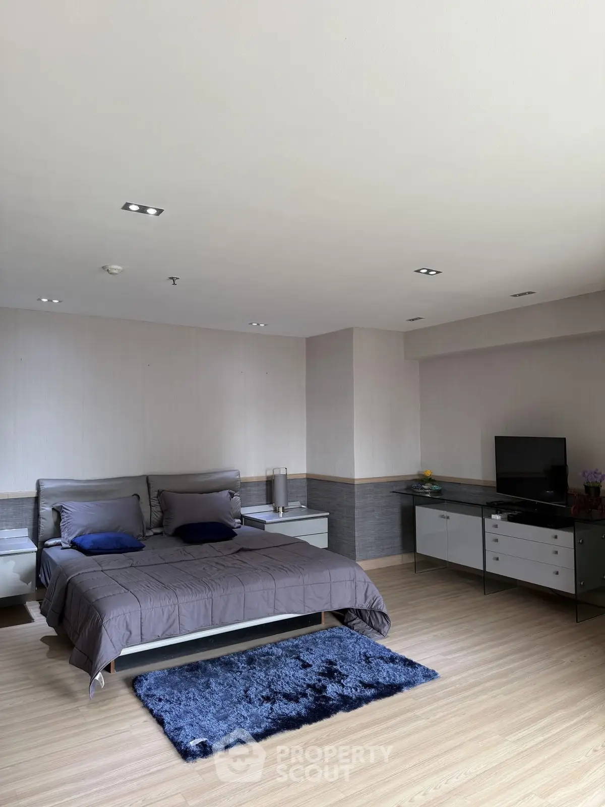 Spacious modern bedroom with stylish decor and natural light