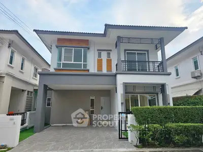 Modern two-story house with sleek design and spacious driveway in suburban neighborhood.