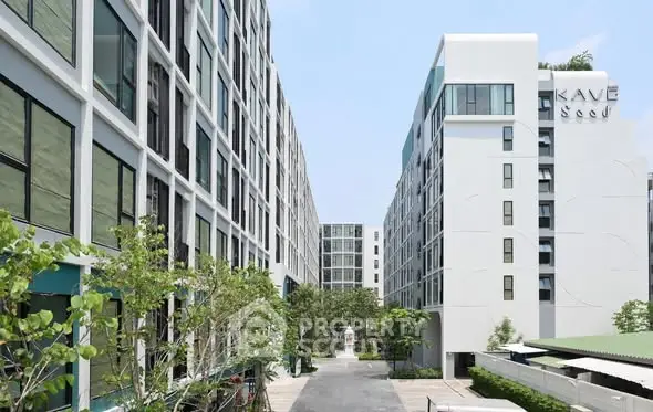Modern apartment complex with lush greenery and clear blue sky