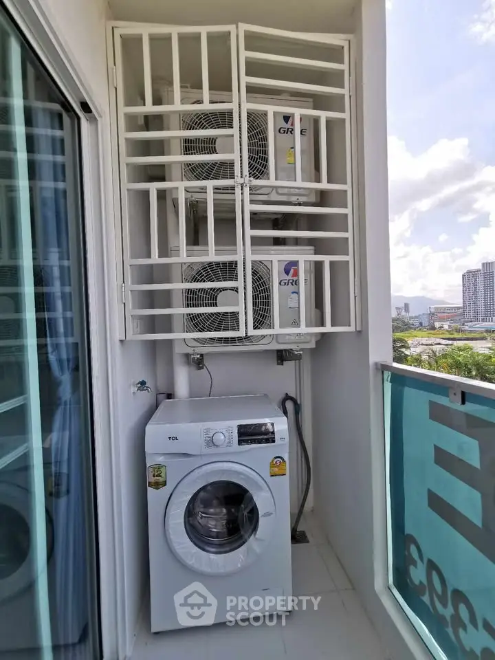 Compact balcony with washing machine and air conditioning units in modern apartment.