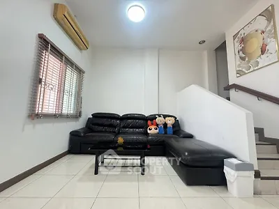 Modern living room with black leather sofa and stylish decor