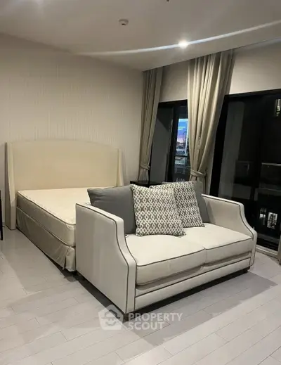 Modern bedroom with elegant sofa and large windows in a stylish apartment.