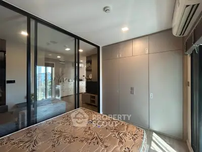 Modern bedroom with glass partition and built-in wardrobe in a stylish apartment.