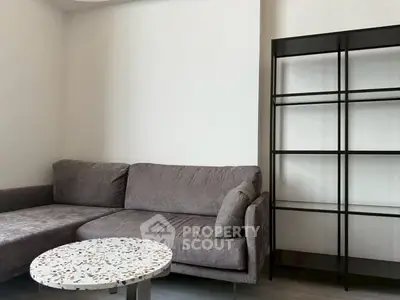 Modern living room with stylish gray sofa and sleek black shelving unit